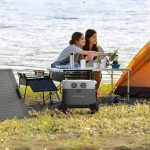 EcoFlow DELTA 3 1500 Portable Power Station connected to a solar panel by the seashore, with two women camping nearby